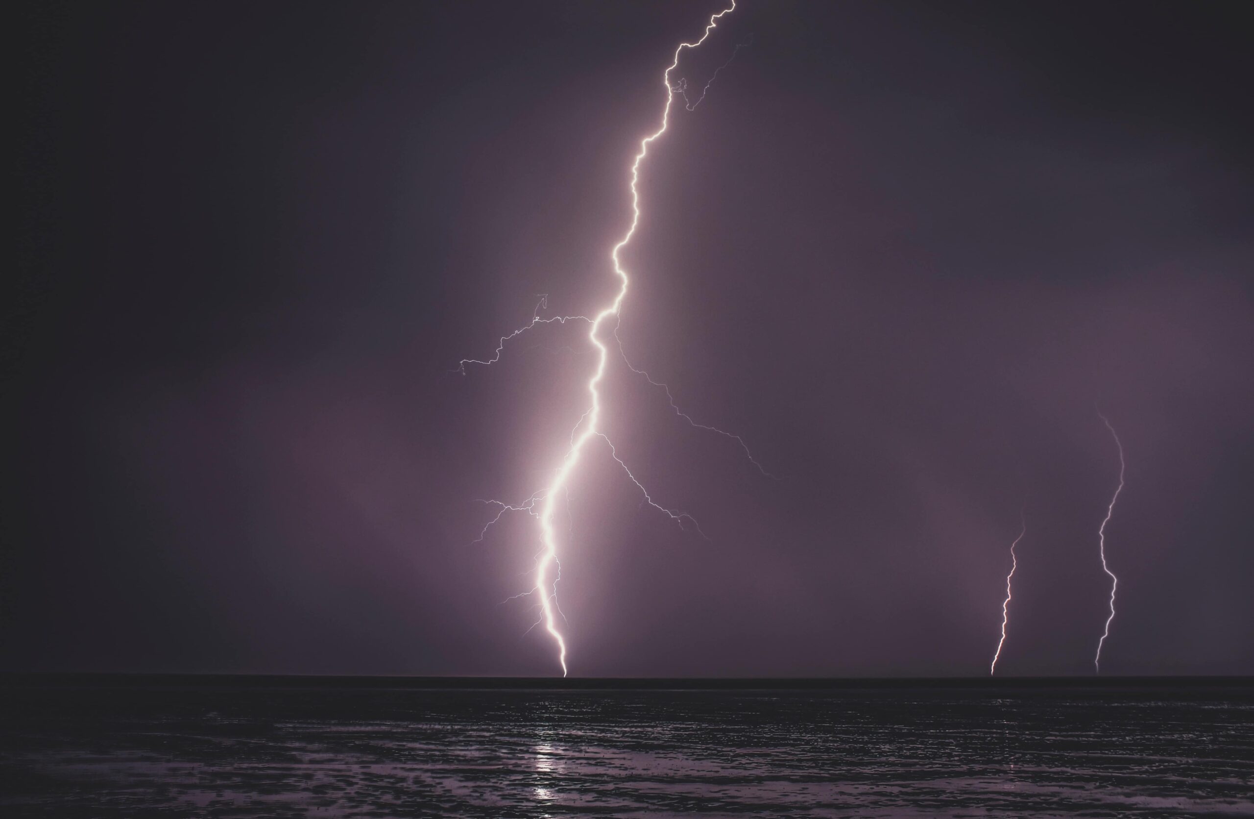 lightning strike during nighttime over body of water